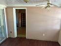View into living room, showing unpainted areas of the wall, hardwood floors and a ceiling fan at 608 Gray Ave, Wildwood, FL 34785