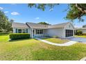Well-maintained home with a covered porch, manicured lawn, and a screened-in garage at 917 Camino Del Rey Dr, Lady Lake, FL 32159