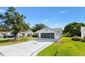Charming home featuring a screened garage, well-maintained lawn, and a delightful palm tree driveway design at 917 Camino Del Rey Dr, Lady Lake, FL 32159