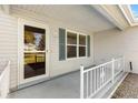 Inviting front porch featuring a glass door, decorative railing, and scenic neighborhood views at 917 Camino Del Rey Dr, Lady Lake, FL 32159