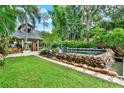 Backyard featuring lush greenery, large stone waterfall, and outdoor dining area at 9642 Bear Lake Rd, Apopka, FL 32703