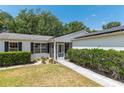Charming front entrance with lush landscaping and a well-manicured lawn at 1212 Chaparral Dr, Lady Lake, FL 32159