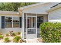 Screened front porch area with a view of the surrounding landscaping and entrance at 1212 Chaparral Dr, Lady Lake, FL 32159