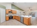 Open kitchen featuring stainless steel appliances, wooden cabinetry, tile flooring, and lots of counter space at 1307 Rain Forest Ln, Minneola, FL 34715