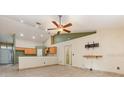 Spacious living room with vaulted ceilings, tile floors, ceiling fan, and kitchen view at 1307 Rain Forest Ln, Minneola, FL 34715