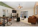 Bright living room with cozy seating, stylish decor, ceiling fan and sliding glass doors to backyard at 1307 Rain Forest Ln, Minneola, FL 34715