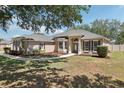 Beautiful single-story house featuring manicured landscaping and an arched entryway at 13301 Biscayne Dr, Grand Island, FL 32735