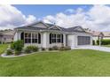 Inviting single-story home with a pristine lawn, complemented by a screened garage and lush landscaping at 17036 Se 79Th Clearview Ave, The Villages, FL 32162