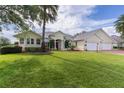 Well-kept lawn and shrubbery complement this beautiful single-story home with a three-car garage at 1721 Sunset Ridge Dr, The Villages, FL 32162