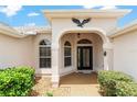 Close up of the front entryway with a decorative eagle accent and glass paneled door at 1875 Saybrook Way, The Villages, FL 32162