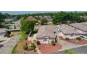 Aerial view of a cozy single-story home with a manicured lawn and vibrant landscaping with decorative rocks at 2128 Alfredo Ave, Lady Lake, FL 32159