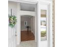 Welcoming foyer showcasing a hardwood floor, decorative wreath, and a glimpse into the home's interior at 2293 Wayland St, The Villages, FL 32162