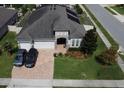Stunning home exterior featuring a stone entrance, well-manicured lawn, and a two-car garage at 2504 Cavender Creek Rd, Minneola, FL 34715