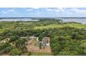 Breathtaking aerial view of a large property with a pool, surrounded by lush greenery and overlooking a serene lake at 6905 Clayton St, Mount Dora, FL 32757