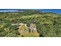 Expansive aerial view of a secluded estate nestled among lush greenery near the waterfront at 6905 Clayton St, Mount Dora, FL 32757