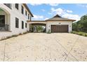 Spacious driveway leading to a detached garage with a porte-cochere, perfect for car enthusiasts and storage at 6905 Clayton St, Mount Dora, FL 32757