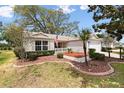 Charming home featuring a manicured lawn, complemented by lush landscaping and mulch at 8097 Se 174Th Belhaven Loop, The Villages, FL 32162