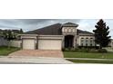 Beautiful single-story house with a three-car garage and well-manicured lawn and landscape at 2504 Cavender Creek Rd, Minneola, FL 34715