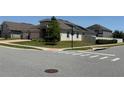 Single-story house with a three-car garage at a street corner, with a well-manicured lawn at 2504 Cavender Creek Rd, Minneola, FL 34715