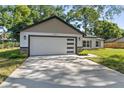 Charming single-Gathering home featuring a modern garage door and well-manicured lawn and landscaping at 10033 Canterbury Dr, Leesburg, FL 34788