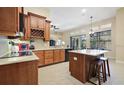 Spacious kitchen with wood cabinetry, an island with seating, and stainless steel appliances at 105 E Blue Water Edge Dr, Eustis, FL 32736