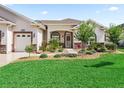 Charming single-story home featuring a well-manicured lawn and beautiful landscaping at 10977 Se 169Th Ln, Summerfield, FL 34491
