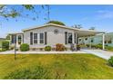 Charming single-story home with well-manicured lawn and appealing landscaping featuring a covered carport at 1109 Paradise Dr, The Villages, FL 32159
