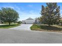 Well-maintained home with a spacious driveway and mature trees enhancing curb appeal at 1140 Eureka Mill Run, The Villages, FL 32162