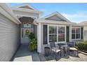Inviting entryway with decorative door and a cozy seating area on the front porch at 1140 Eureka Mill Run, The Villages, FL 32162