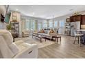 Open-concept living room with stylish furniture, hardwood floors, and abundant natural light at 13304 Magnolia Valley Dr, Clermont, FL 34711