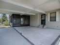 Spacious carport with an attached screened-in porch area with tile flooring and a side entry door at 1437 Apache Cir, Tavares, FL 32778