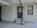 Close-up of the home's side entrance with steps, railing, and a storm door at 1437 Apache Cir, Tavares, FL 32778