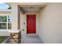 Close-up of a red front door with stone accents, creating a welcoming entrance at 15117 Se 94Th Ter, Summerfield, FL 34491