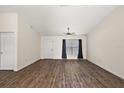 Spacious living room featuring wood-look floors, a window, and a white door at 15117 Se 94Th Ter, Summerfield, FL 34491