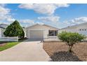 Charming single-story home with light siding, attached garage, white picket fence, and well maintained landscaping at 1622 Navidad St, The Villages, FL 32162