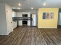 Modern kitchen features stainless steel appliances, white cabinets and an adjacent dining area at 1721 Nebraska Loop, Sumterville, FL 33585