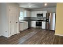Modern kitchen with stainless steel appliances, white cabinets, and ample counter space at 1721 Nebraska Loop, Sumterville, FL 33585