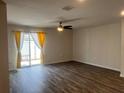 Bright living room featuring wood-look flooring and sliding glass doors to the outdoor patio at 1721 Nebraska Loop, Sumterville, FL 33585