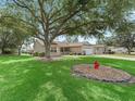 A beautiful home with a large tree in the front yard providing shade and enhancing curb appeal at 17349 Se 76Th Flintlock Ter, The Villages, FL 32162