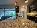 Spacious kitchen featuring granite countertops, a large island, and modern pendant lighting at 1893 Banning Beach Rd, Tavares, FL 32778