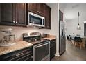 Stylish kitchen boasts stainless steel appliances, dark wood cabinets, and granite countertops at 1893 Banning Beach Rd, Tavares, FL 32778