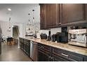 Spacious kitchen with dark wood cabinetry, stainless steel appliances, and granite countertops at 1893 Banning Beach Rd, Tavares, FL 32778