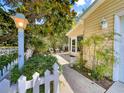 Inviting home featuring lush landscaping, a charming walkway, and a cozy front porch area with outdoor seating at 2102 Estevez Dr, Lady Lake, FL 32159