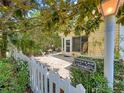 Beautiful home entrance with a white picket fence, a charming courtyard with seating, and lush greenery at 2102 Estevez Dr, Lady Lake, FL 32159