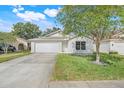 Charming single-story home featuring a well-manicured lawn and two car garage at 2136 Fish Eagle St, Clermont, FL 34714