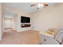 Cozy living room with neutral carpet, ceiling fan, and mounted television at 2136 Fish Eagle St, Clermont, FL 34714