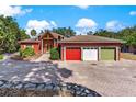Inviting home with a circular driveway, three-car garage, and lush landscaping against a sunny sky at 2400 N Griffin Dr, Leesburg, FL 34748