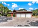 Elegant home featuring a 3-car garage, landscaped yard, and brick paved circular driveway at 2400 N Griffin Dr, Leesburg, FL 34748