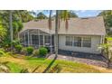 Backyard featuring a screened-in lanai and a well-maintained lawn, providing a perfect space for outdoor relaxation at 25129 Riverwalk Dr, Leesburg, FL 34748