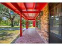 Inviting front porch with mosaic-style flooring, brick accents, and red support columns at 274 W Kings Hwy, Center Hill, FL 33514
